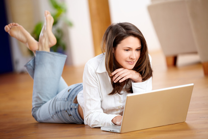 Frau am Computer auf dem Boden liegend